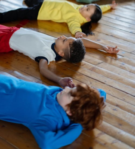 Children lying on brown hardwood floor