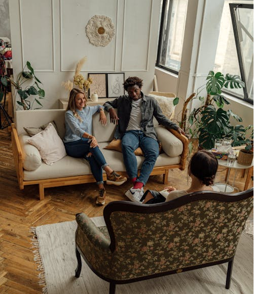 Two women and a man sitting together in a room while talking