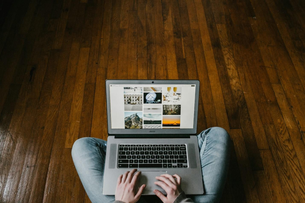 Cropped photo of a man sitting on a clean floor with laptop