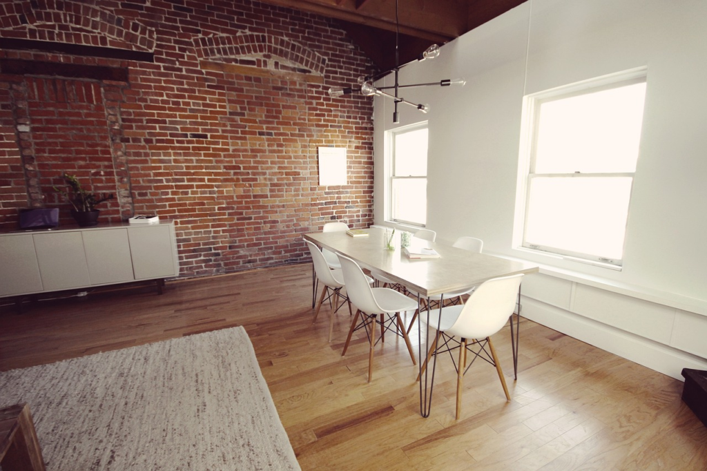 Living room with brick walls and shiny hardwood floor